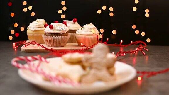 餐桌上有传统美味的圣诞自制糖果姜饼饼干后面有奶油的圣诞蛋糕