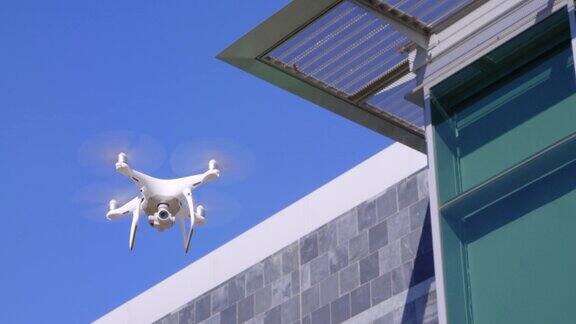 现代无人机飞行与商业建筑和蓝天的背景