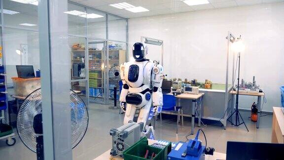 微笑的半机械人正在实验室里移动它的头部和身体