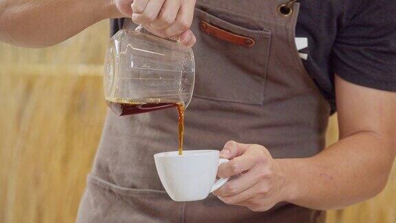 专业的咖啡师将煮好的咖啡倒入杯子中