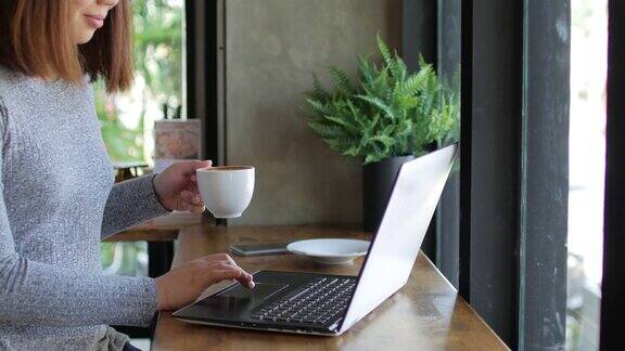 女人用她的笔记本电脑在咖啡馆放松时间摄影