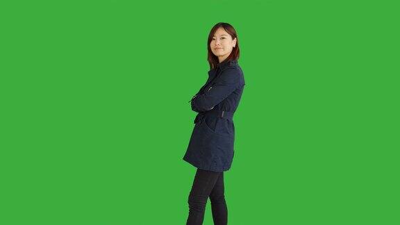 年轻的亚洲妇女站在绿色屏风的背景下孤立中国女性人物肖像