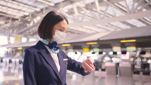新冠肺炎疫情期间飞机上的空乘人员戴着口罩走在机场航站楼走向飞机以预防新冠肺炎感染航空运输的新常态生活理念