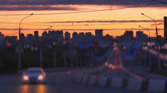 镜头模糊汽车在剪影的背景下行驶欧洲城市美丽的日落全景Tilt-shift镜头
