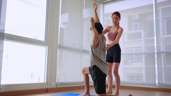 亚洲年轻的没有手臂的截肢者在健身房与教练一起做瑜伽有吸引力的快乐残疾运动员在体育馆里进行运动和锻炼以保持肌肉的健康和健康