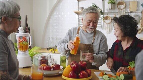 一群亚洲老年人朋友在厨房为朋友制作果汁五颜六色的水果和蔬菜健康饮食