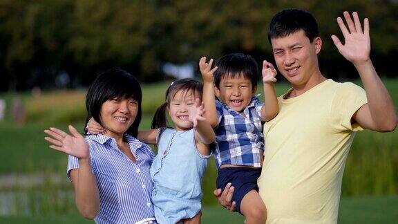快乐的亚洲家庭一起在户外挥手