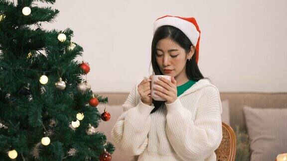 圣诞节庆祝理念亚洲女人喝着咖啡幸福地看着圣诞树