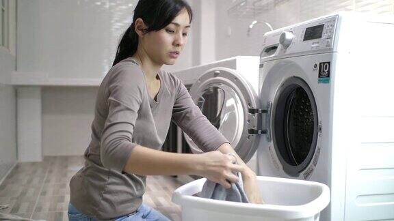 在家里用洗衣机洗衣服的女人