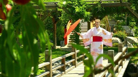 一名身穿和服的年轻女子站在日本花园中一座河上的桥上