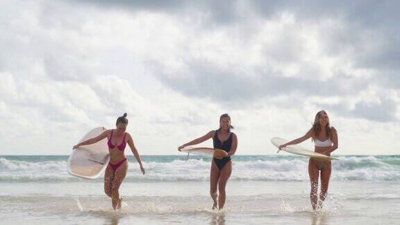4K阳光明媚的日子里一群亚洲女子抱着冲浪板在沙滩上散步