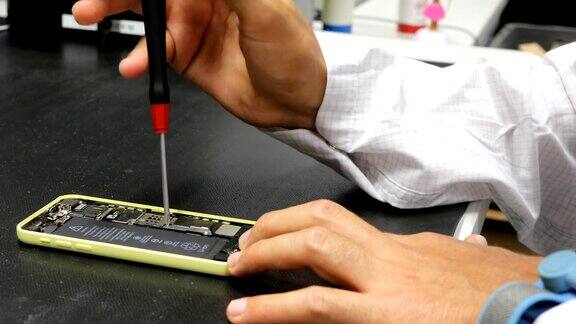 工程师用螺丝刀修理智能手机
