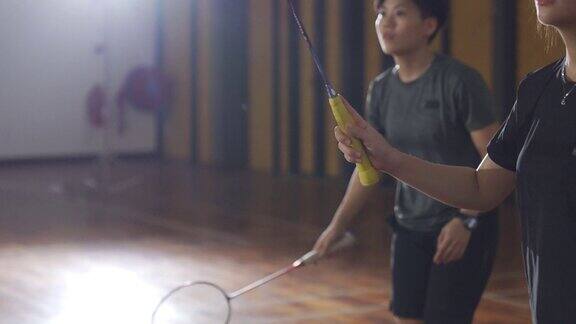 亚洲华人羽毛球运动员在羽毛球场上的手