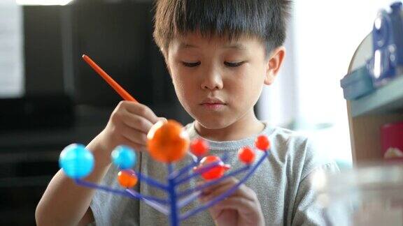 亚洲男孩画太阳系模型创造性和学习