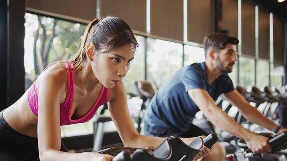 4K超高清慢镜头:一群亚洲人在健身房骑自行车训练