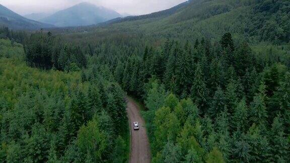 鸟瞰图的越野车移动的路径道路在山区多云雾多雨的天气