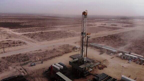 无人机拍摄的西德克萨斯石油和天然气压裂钻机在白天遭遇沙尘暴的画面