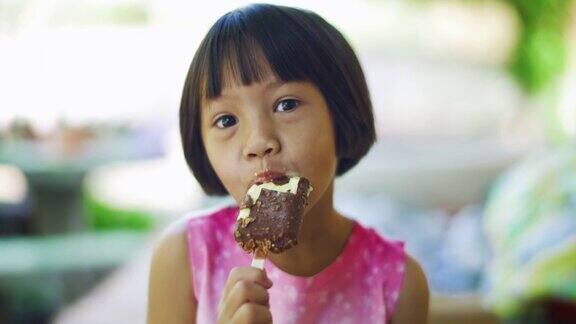 可爱的女孩正带着积极的情绪放松享受吃巧克力冰淇淋零食