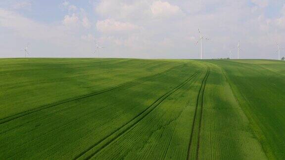 空中拖拉机在被风力涡轮机包围的田地上喷洒杀虫剂