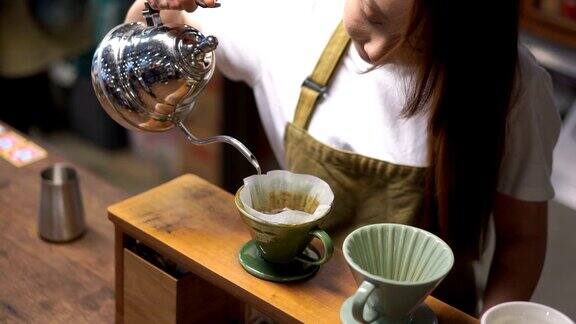 亚洲女人学会了滴咖啡咖啡师正在准备滴煮咖啡