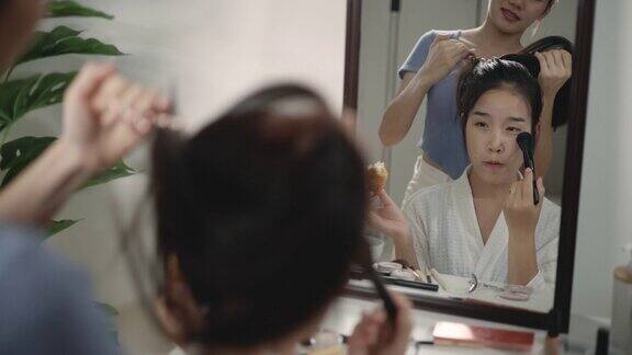 一个年轻漂亮的亚洲女人在镜子前化妆