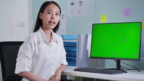领导亚洲美丽的女商人呈现在绿色屏幕的电脑在一个会议远程绿屏