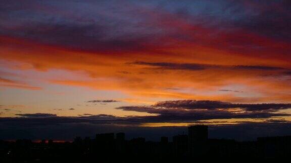 橘色日落的时间流逝深蓝色的云漂浮在金色的天空上