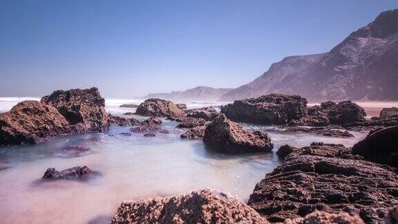 潮海水蓝色的水在岩石海岸海风在海浪上溅起水花