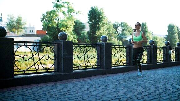 活跃的女人在城市人行桥上慢跑跑步