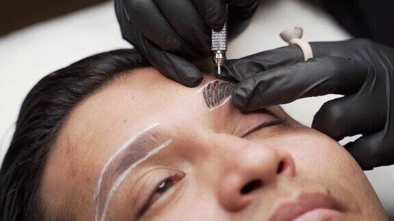 近距离拍摄的男性微刮刀程序使永久眉毛化妆