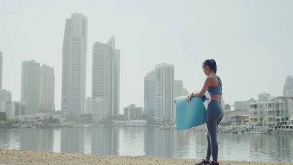 年轻的亚洲女性在公园练习在线瑜伽自我护理积极健康的生活方式