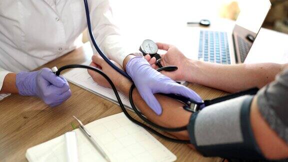 医生心脏科治疗师在门诊为男病人测量血压