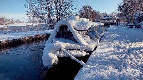 在寒冷的冬天英国运河水道上的一艘狭窄的船