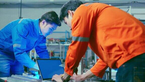 男亚洲工程师专业人员站在工厂的机器旁边讨论两个亚洲同事头脑风暴解释和解决机器的过程