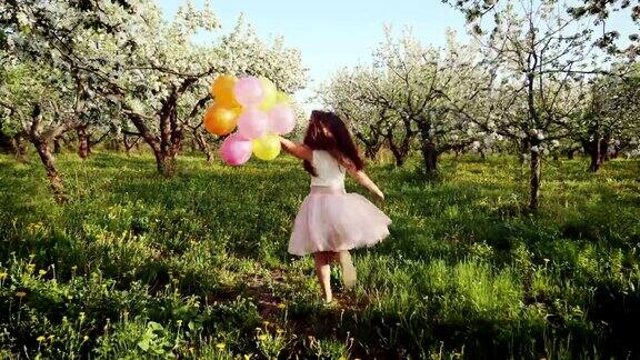 快乐的女孩与气球在盛开的花园中奔跑