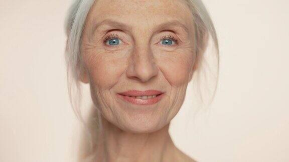 美丽的老年妇女转过身看着相机美妙的微笑的特写肖像老美优雅的老年理念在护肤品化妆品产品逐渐关注