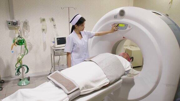 一位中年男子躺在CT扫描仪上机器对他的身体进行成像