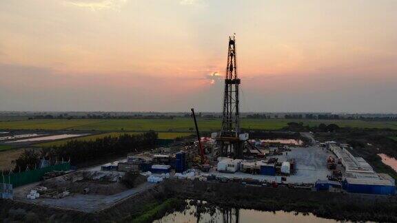 夕阳下的石油钻塔在稻田里