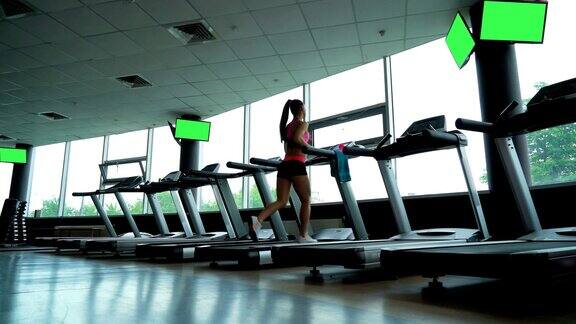 年轻女子在健身俱乐部的跑步机上训练