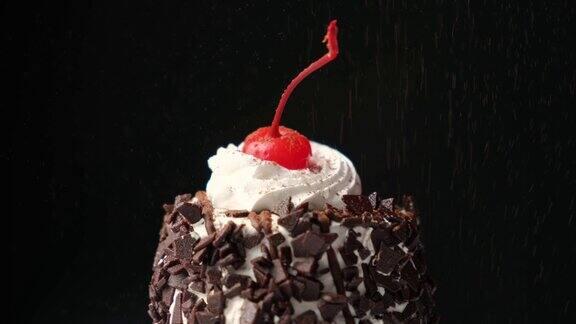 巧克力蛋糕上撒着可可黑色背景是樱桃釉和奶油