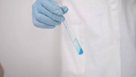 化学实验室白光房间穿白大褂的研究员进行生物实验装有蓝色液体的试管液体的研究孩子的研究