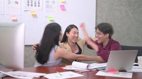 一群亚洲年轻商业女性或办公室女性使用电脑在现代办公室一起讨论工作的4k视频快乐和成功的情绪概念