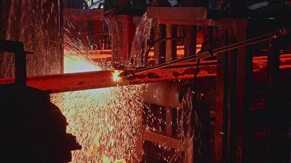 钢铁工人使用气体切割机手动切割钢坯