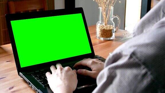 摄影:商人在笔记本电脑上工作绿色屏幕为色键的客厅-家庭室内场景