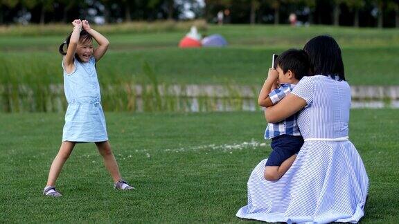 妈妈在公园里拍摄有趣的亚洲小女孩