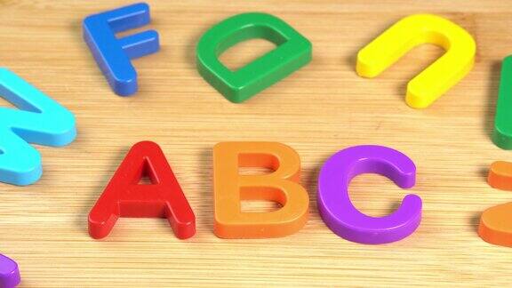 彩色ABC字母在木制背景上旋转学习学校或大学和知识塑料英文字母拉丁文