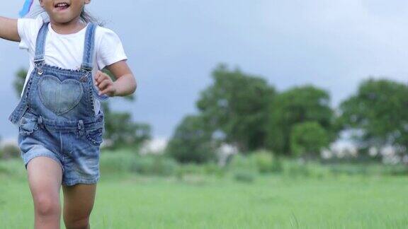 亚洲的孩子女孩和父亲与风筝跑和快乐的草地在夏季的自然