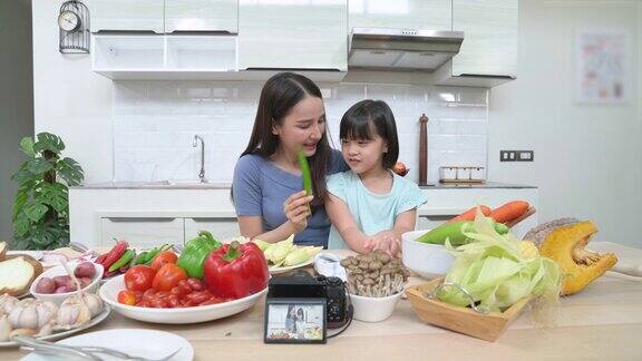 家庭儿童和快乐的人亚洲母亲和孩子在厨房做饭快乐的亚洲女性视频博主直播在线教学烹饪食物在家厨房