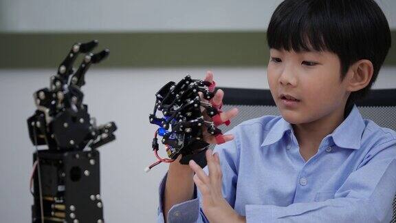 亚洲发明家孩子组装和测试机器人反应在实验室建筑师小孩子设计电路技术想法和协作开发机器人