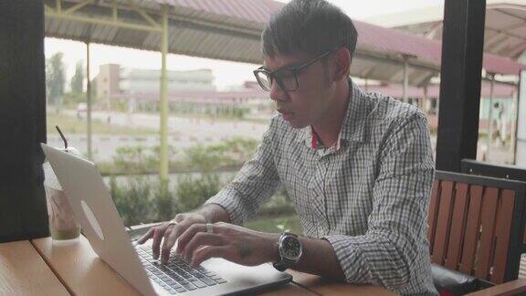 亚洲商人在咖啡馆用笔记本电脑工作